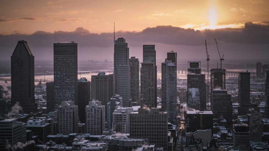A picture of the Montreal skyline, with a purple and orange sky. Photo credit: eliastookit